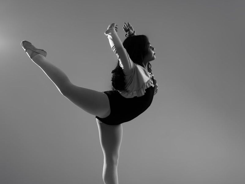 Person performing a controlled, focused movement in a minimalist space.